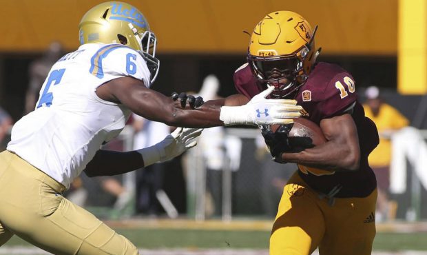 Arizona State wide receiver Kyle Williams, right, fends off the tackle of UCLA safety Adarius Picke...