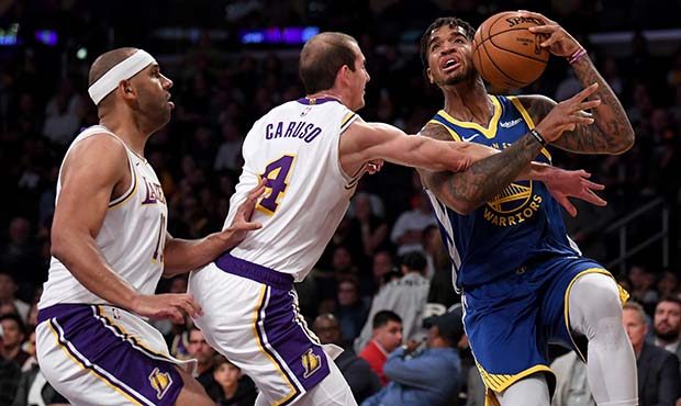 Marquese Chriss #32 of the Golden State Warriors is fouled by Alex Caruso #4 of the Los Angeles Lak...