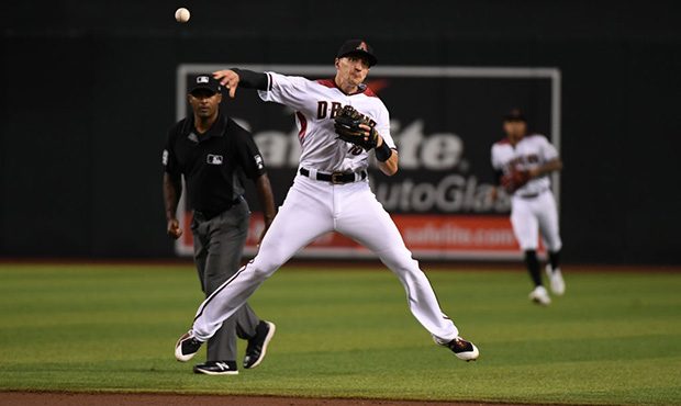 PHOENIX, ARIZONA - JULY 24: Nick Ahmed #13 of the Arizona Diamondbacks makes a running throw to fir...