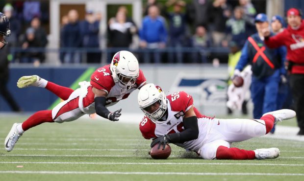SEATTLE, WASHINGTON - DECEMBER 22: Jordan Hicks #58 recovers a fumble recovery alongside Jalen Thom...