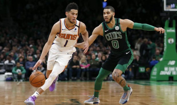 Phoenix Suns guard Devin Booker (1) drives past Boston Celtics forward Jayson Tatum (0) during the ...