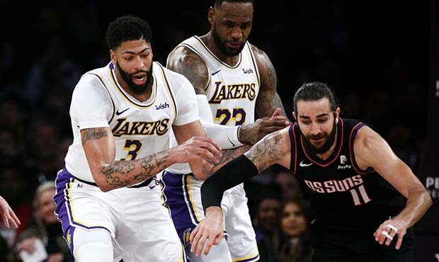 Phoenix Suns' Ricky Rubio (11) keeps the ball away from Los Angeles Lakers' Anthony Davis (3) and L...