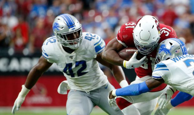 Running back David Johnson #31 of the Arizona Cardinals is tackled by Tracy Walker #21 of the Detro...