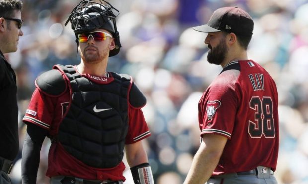 From left, umpire Chris Conroy confers with Arizona Diamondbacks catcher Carson Kelly and starting ...