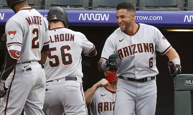 Arizona Diamondbacks' Kole Calhoun (56) is congratulated by David Peralta as Calhoun returns to the...