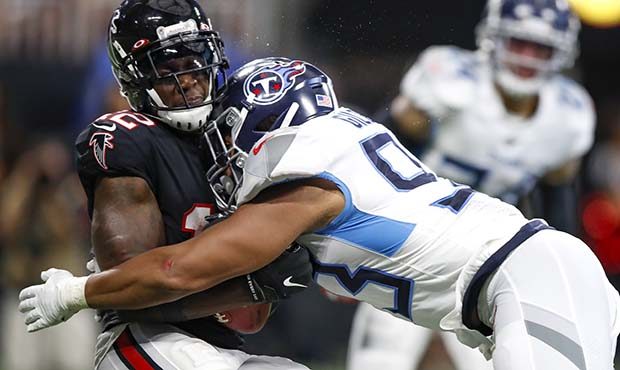 Mohamed Sanu #12 of the Atlanta Falcons is hit by Reggie Gilbert #93 of the Tennessee Titans in the...