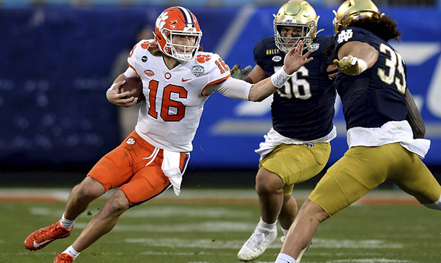 Clemson quarterback Trevor Lawrence, left, rushes against Notre Dame during the Atlantic Coast Conf...