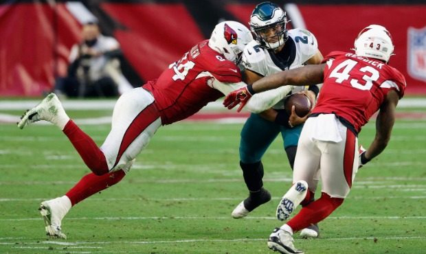 Jalen Hurts #2 of the Philadelphia Eagles is sacked by Zach Allen #94 and Andy Lee #4 of the Arizon...