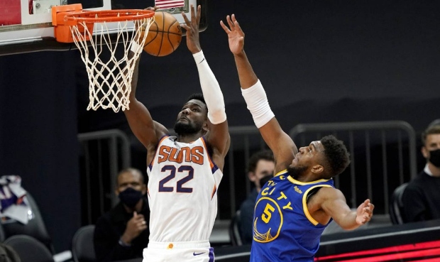 Phoenix Suns center Deandre Ayton (22) shoots past Golden State Warriors forward Kevon Looney (5) d...