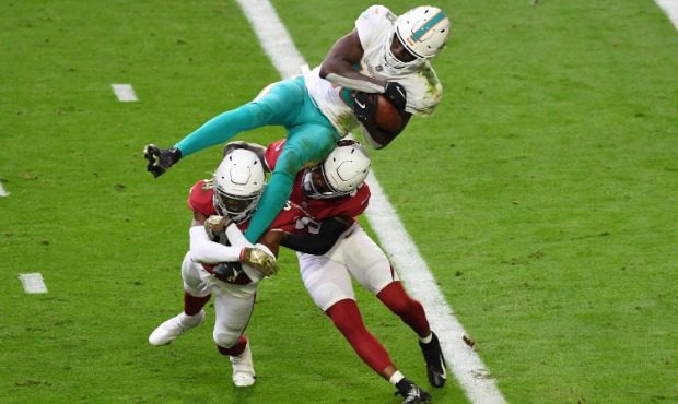 Preston Williams #18 of the Miami Dolphins dives into the end zone for a touchdown as Jalen Thompso...