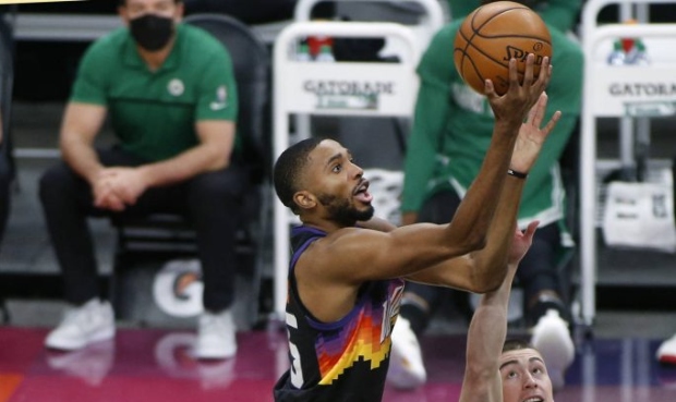 Phoenix Suns forward Mikal Bridges, left, shoots over the defense of Boston Celtics guard Payton Pr...