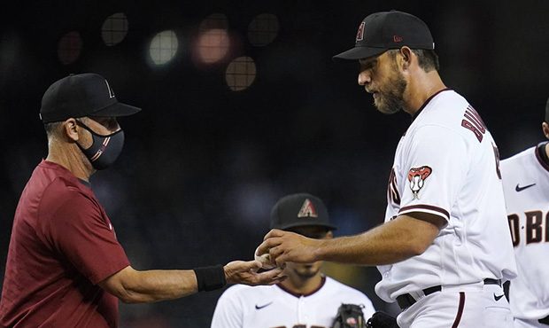 Arizona Diamondbacks starting pitcher Madison Bumgarner, right, hands the baseball over to manager ...