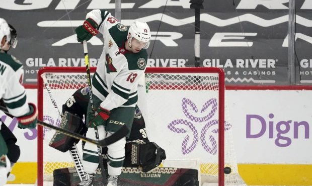 The puck goes wide of the net as Minnesota Wild center Nick Bonino (13) blocks the view of Arizona ...