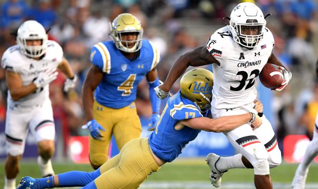 James Wiggins #32 of the Cincinnati Bearcats returns a kick as he is tackled by JJ Molson #17 of th...