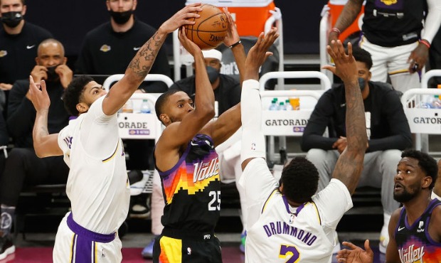 Mikal Bridges #25 of the Phoenix Suns attempts a shot against Anthony Davis #3 and Andre Drummond #...