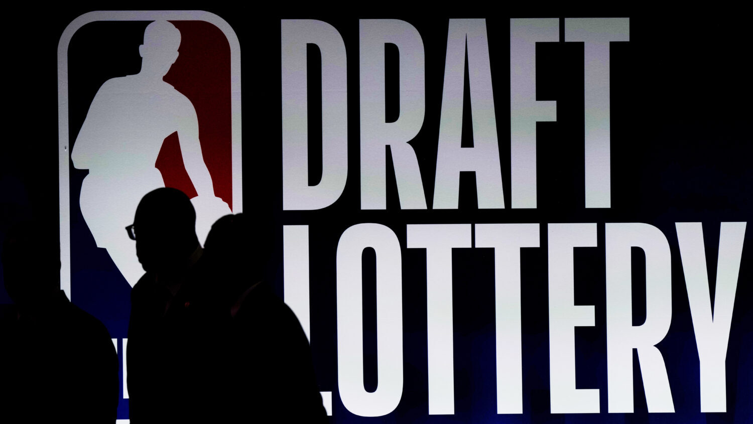 People walk by a sign during the NBA Draft Lottery...