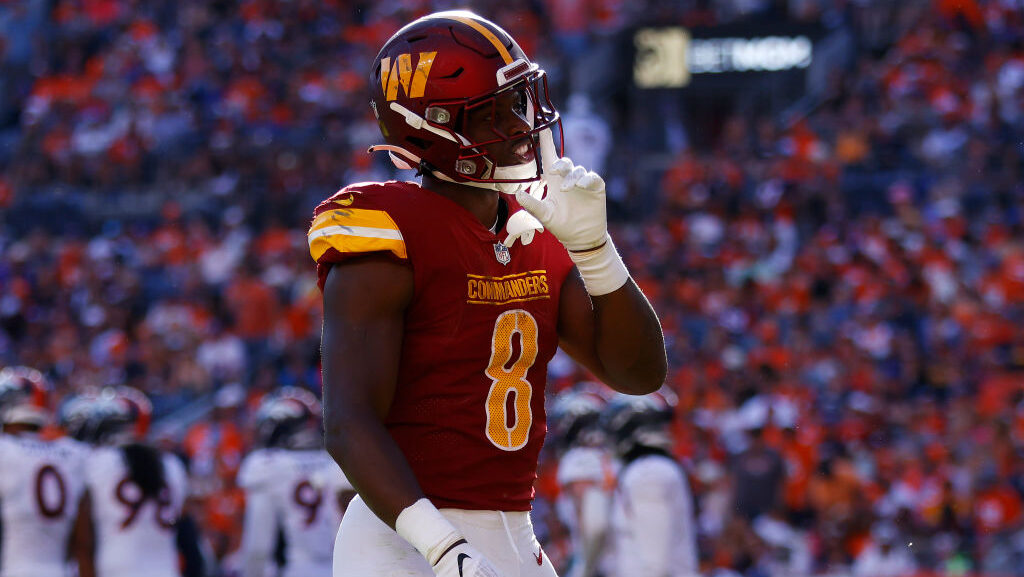 Brian Robinson Jr. #8 of the Washington Commanders celebrates after scoring a rushing touchdown dur...