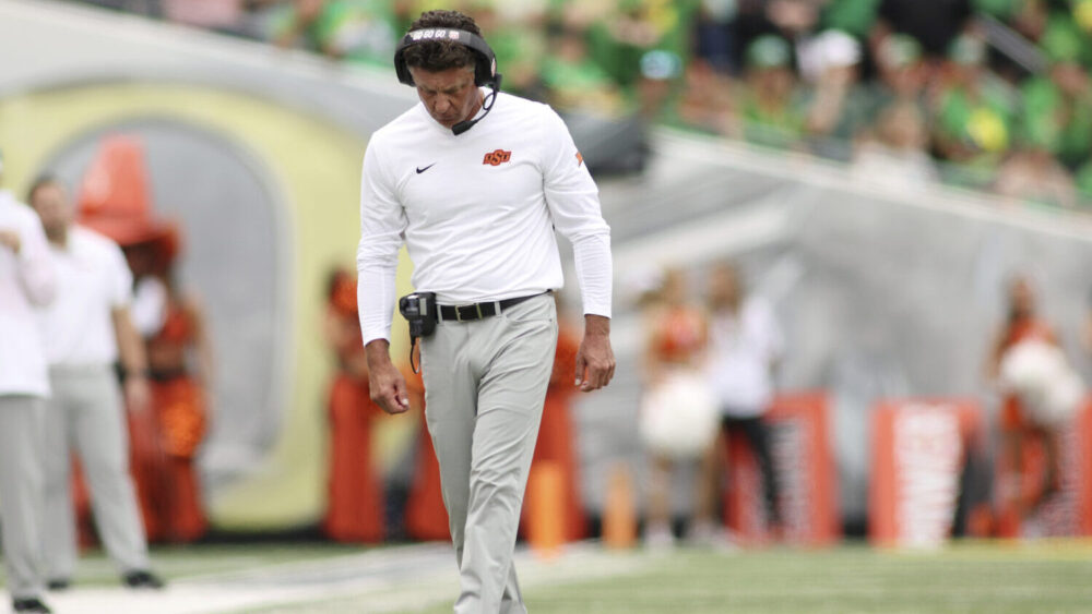 Oklahoma State head coach Mike Gundy walks on the field during the first half of an NCAA college fo...