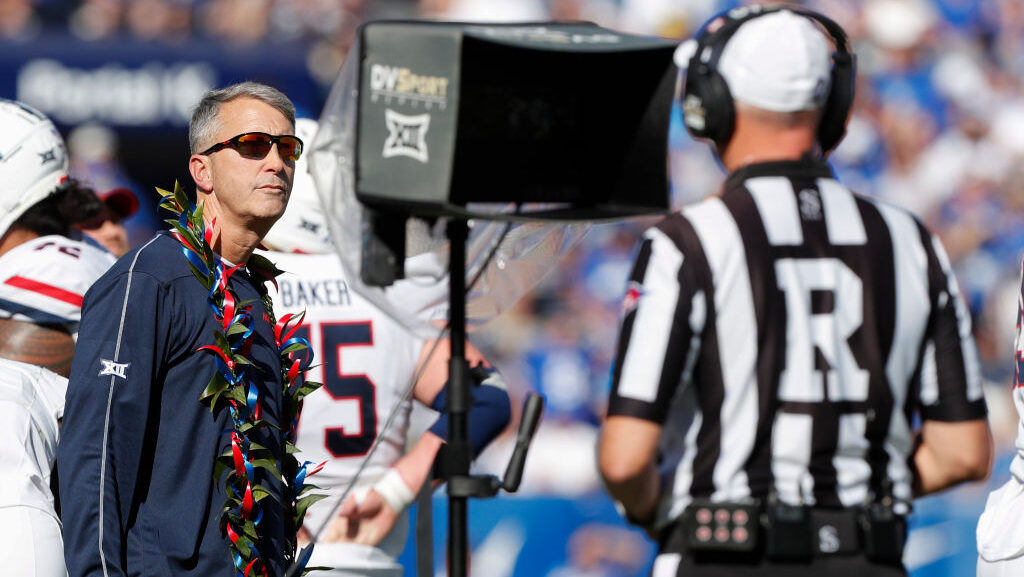 Head coach Brent Brennan of the Arizona Wildcats watches as referee Mike McCabe reviews a play duri...
