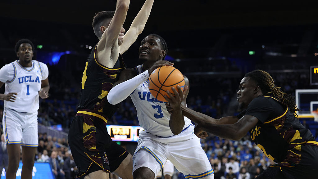 UCLA Bruins forward Eric Dailey Jr. #3 heavily guarded by members of the Arizona State Sun Devils d...