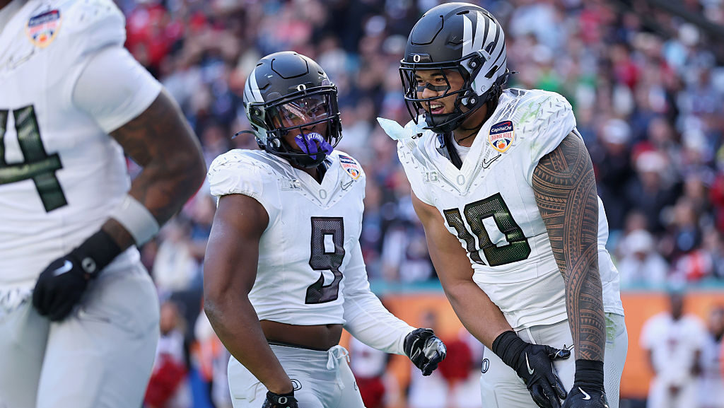 Matayo Uiagalelei #10 of the Oregon Ducks celebrates with teammates after a fumble recovery against...