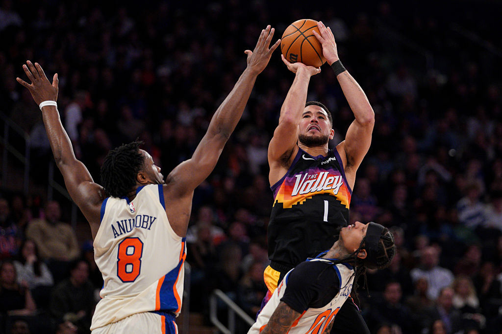 NEW YORK, NEW YORK - JANUARY 17: Devin Booker #1 of the Phoenix Suns shoots as OG Anunoby #8 and Jo...