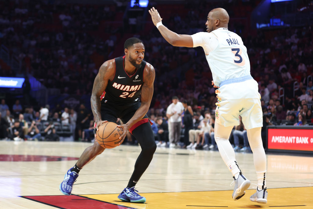 MIAMI, FLORIDA - JANUARY 19: Haywood Highsmith #24 of the Miami Heat drives against Chris Paul #3 o...