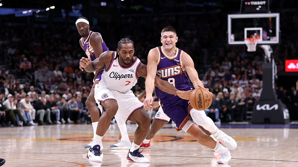 Grayson Allen #8 of the Phoenix Suns drives to the basket against Kawhi Leonard #2 of the Los Angel...