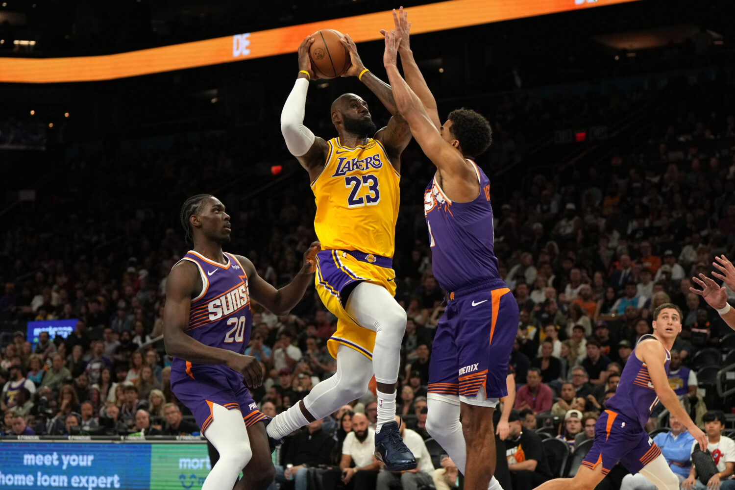 Los Angeles Lakers forward LeBron James drives between Phoenix Suns forward Rasheer Fleming (20) an...