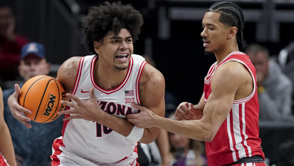 Koa Peat #10 of the Arizona Wildcats drives against Milos Uzan #7 of the Houston Cougars...