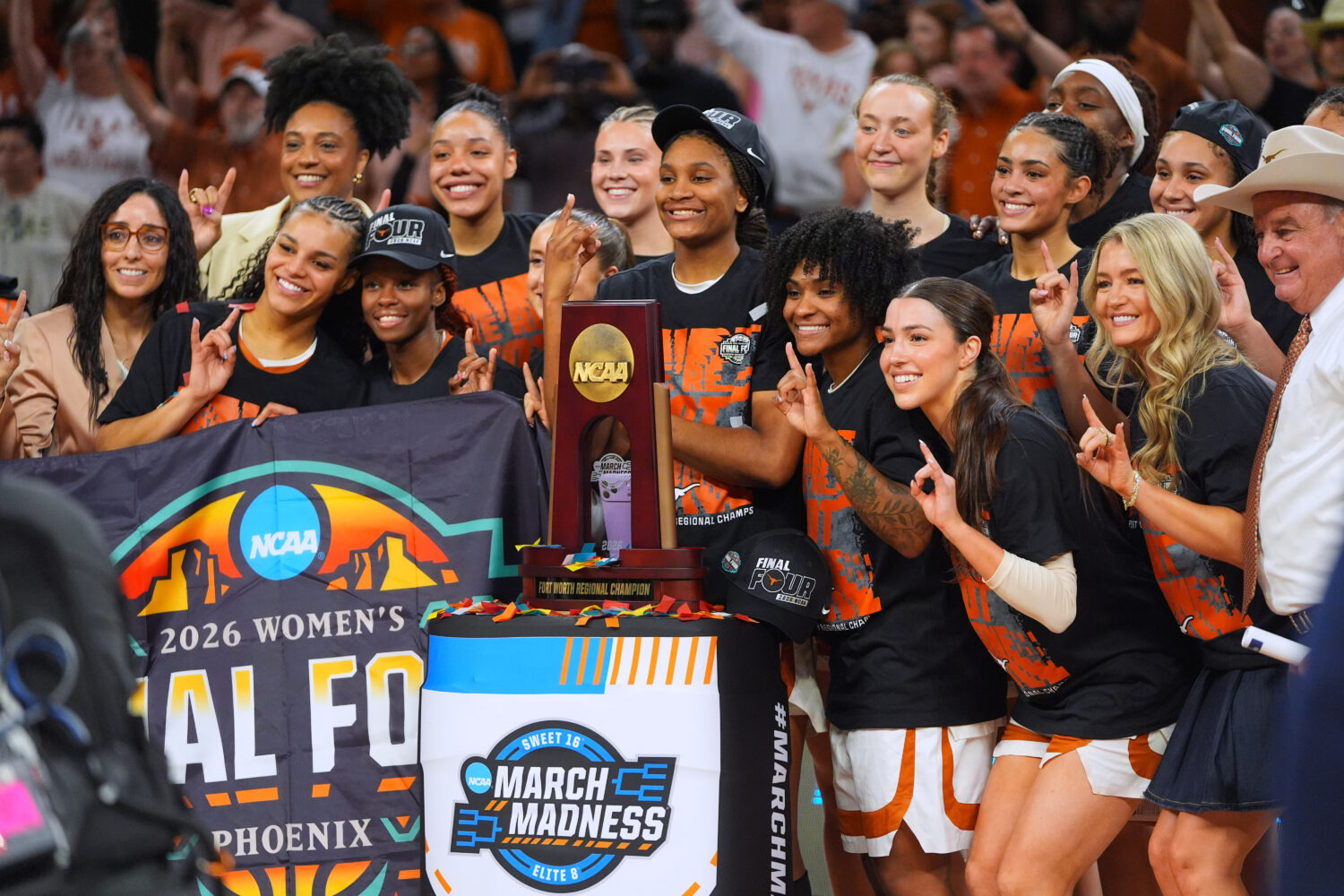 Texas players pose after beating Michigan in the Elite Eight of the NCAA college basketball tournam...