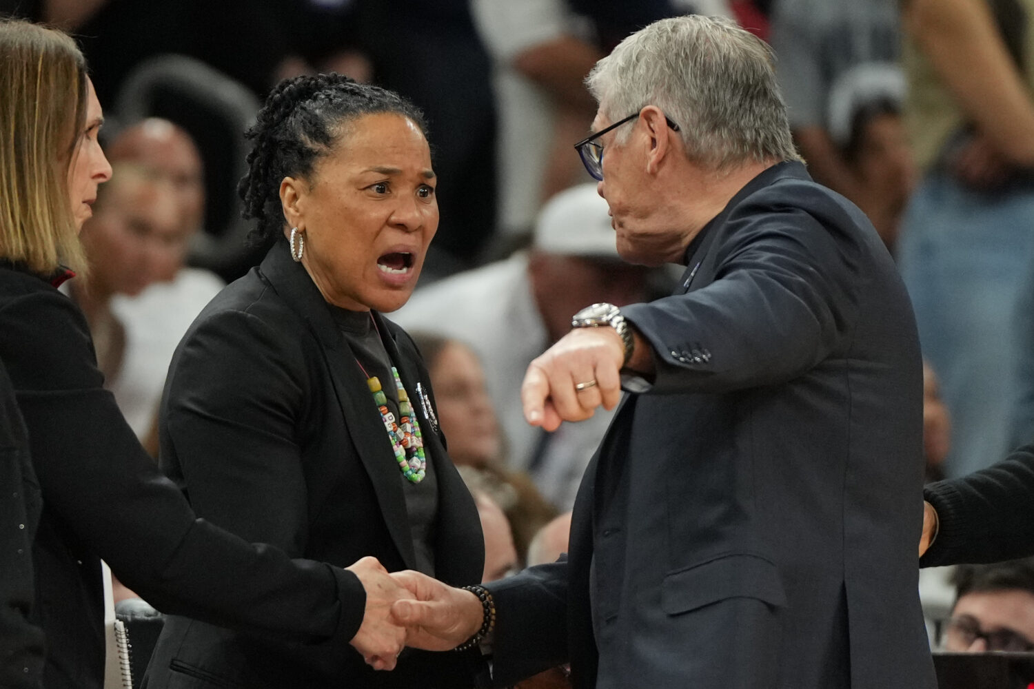 South Carolina head coach Dawn Staley, center, and UConn head coach Geno Auriemma argue after a wom...