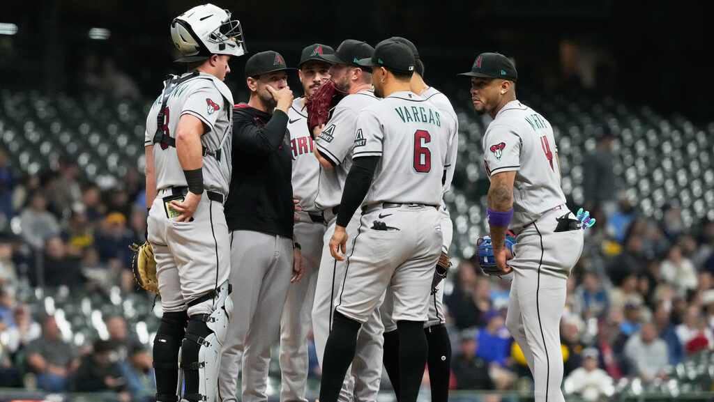 Diamondbacks pitching coach Brian Kaplan talks to pitcher Merrill Kelly...