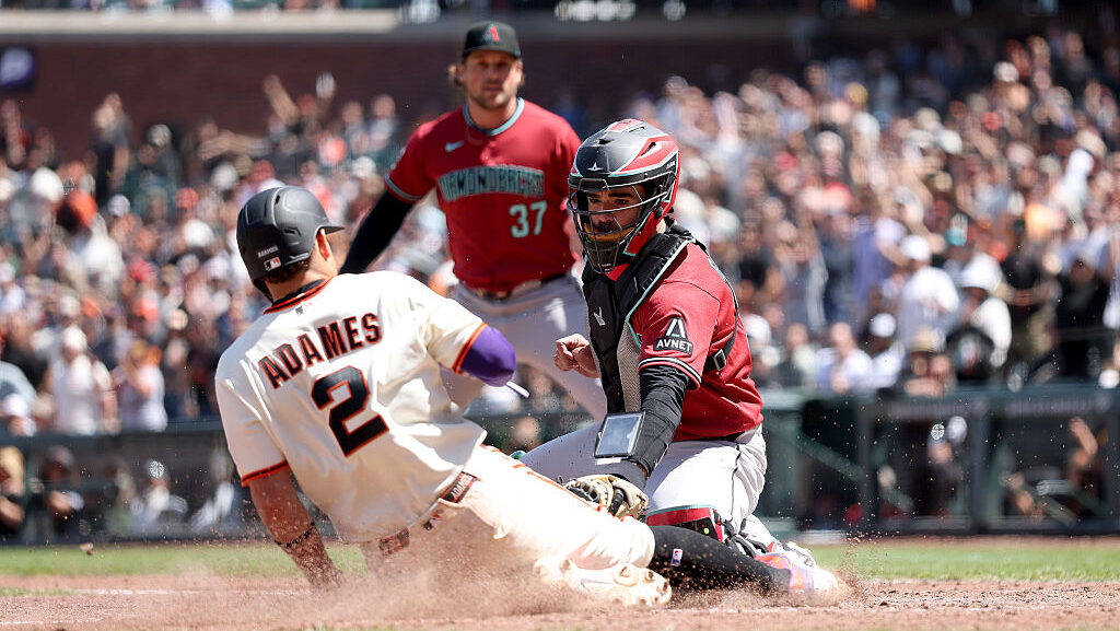 Willy Adames #2 of the San Francisco Giants is tagged out by Aramis Garcia #35 of the Arizona Diamo...