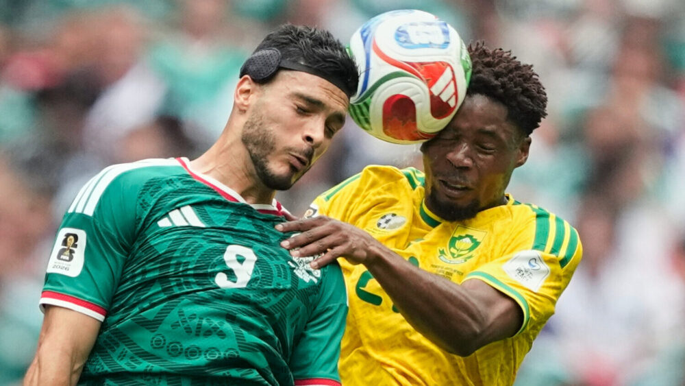 Mexico's Raul Jimenez, left, jumps for the ball with South Africa's Ime Okon during the World Cup G...