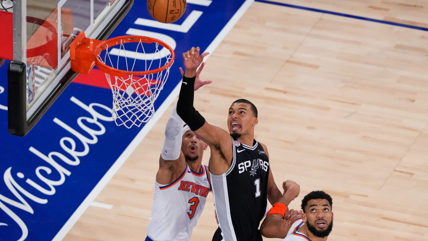 San Antonio Spurs forward Victor Wembanyama (1) shoots as New York Knicks guard Josh Hart (3) and c...