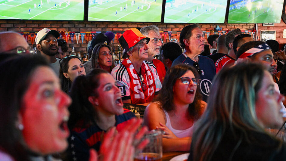 Fans react as they watch on TV the 2026 World Cup round of 16 match between USA and Belgium at Joxe...