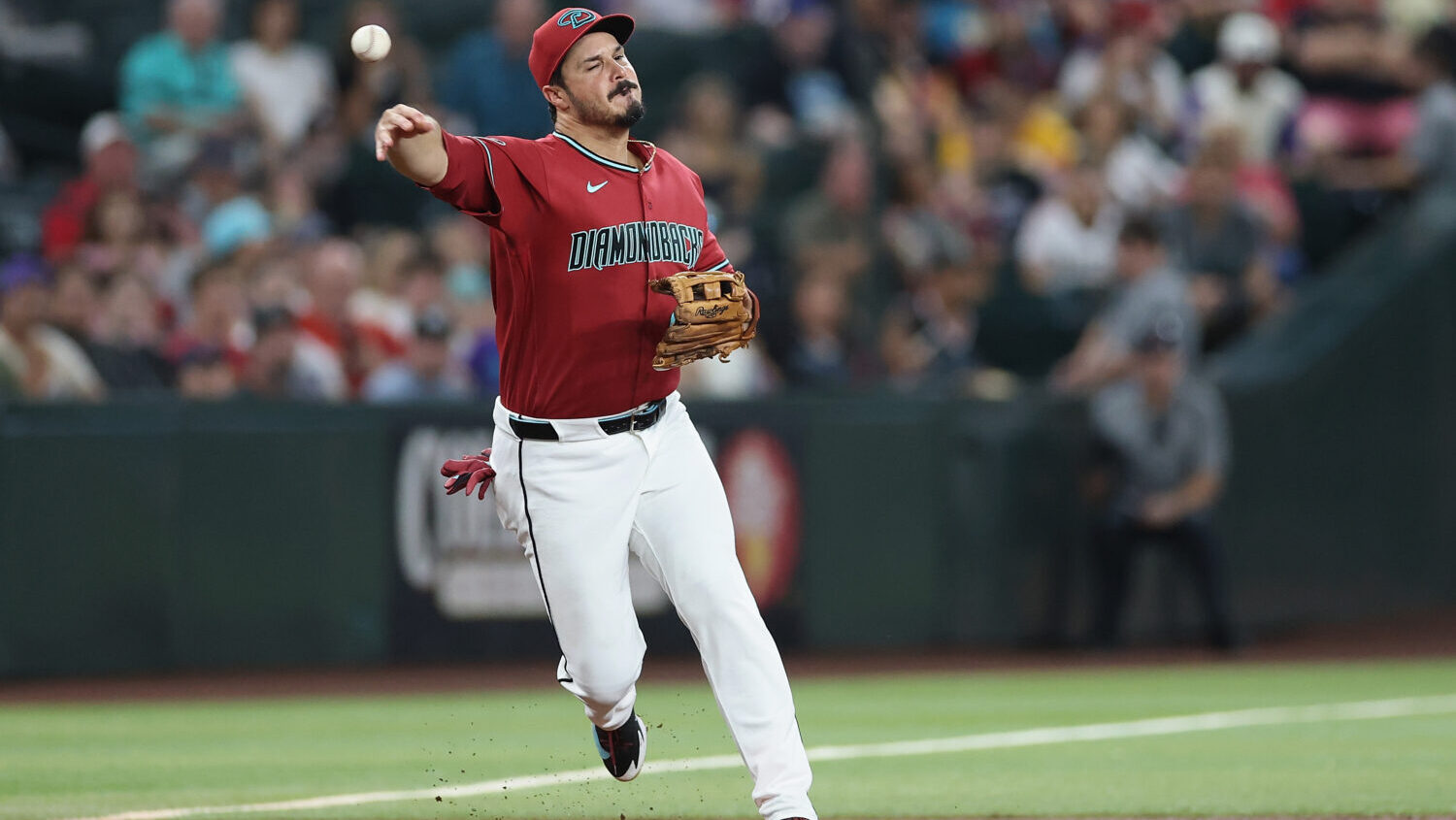 PHOENIX, ARIZONA - AUGUST 11: Nolan Arenado #28 of the Arizona Diamondbacks fields a ground-ball ou...