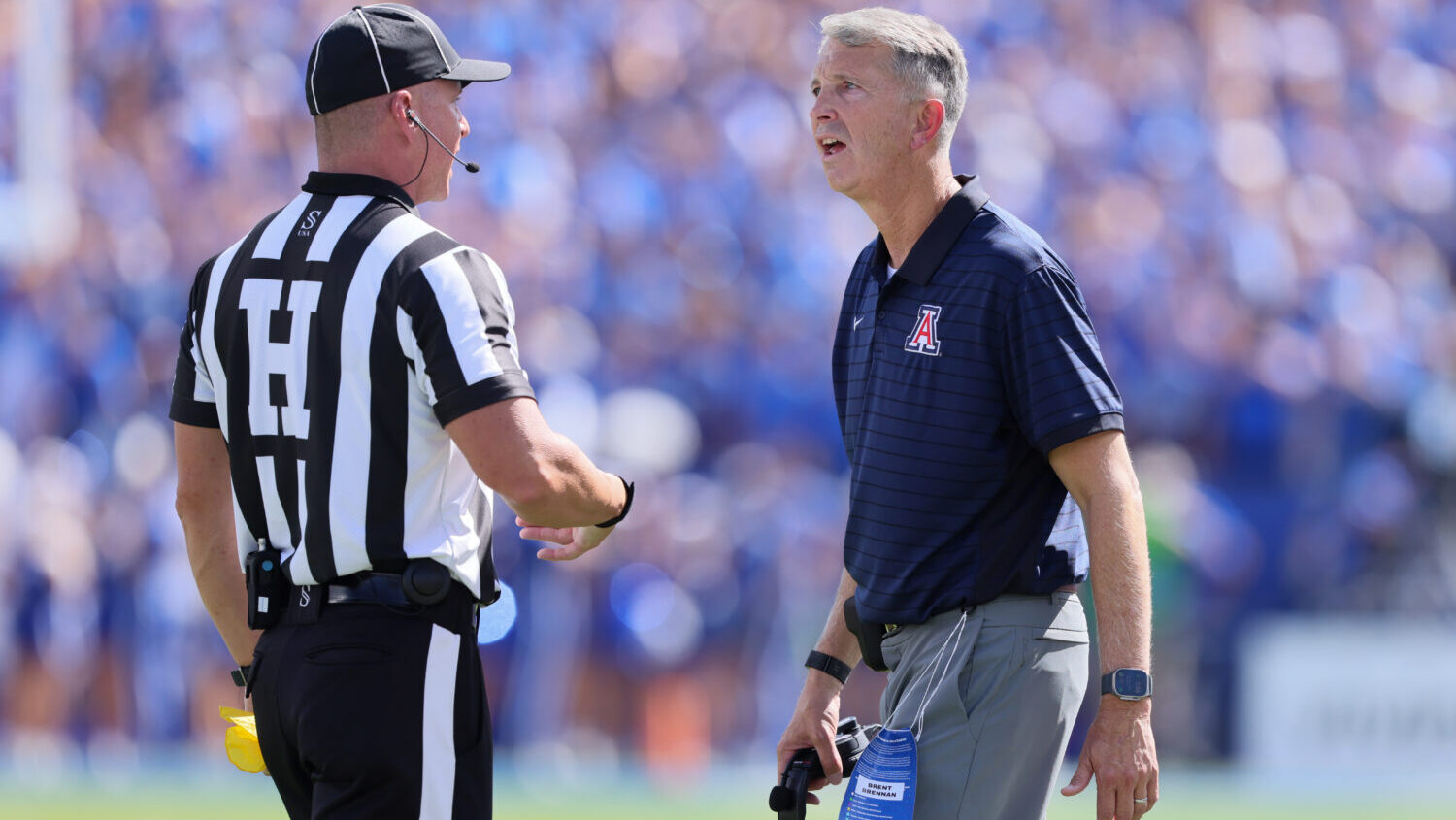 Head Coach Brent Brennan of the Arizona Wildcats questions a call with Head Lines Judge Eric Carmou...
