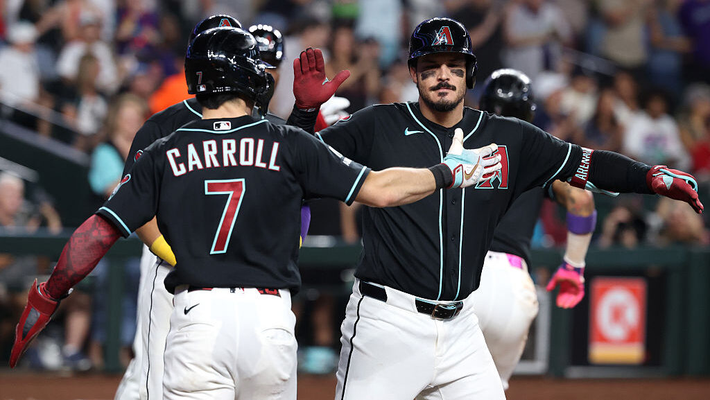Nolan Arenado #28 high fives Corbin Carroll #7 of the Arizona Diamondbacks...