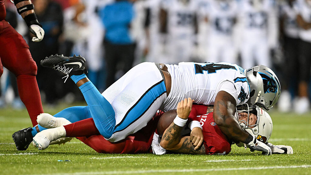 Jared Harrison-Hunte #94 of the Carolina Panthers sacks Carson Beck #19 of the Arizona Cardinals du...